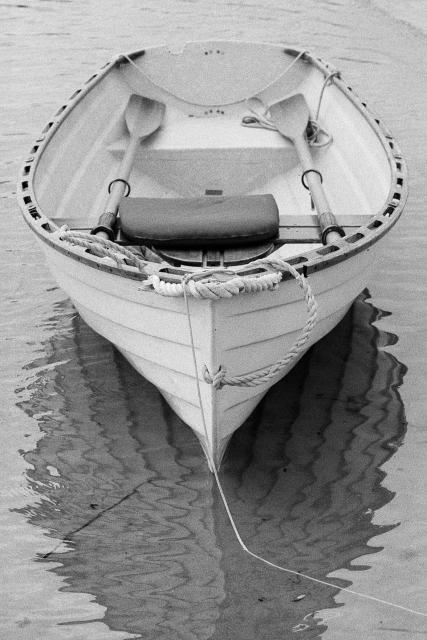 A rowboat floats in the shallows.