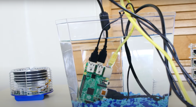 raspberry pi with all wires connected in a fish tank of clear liquid
