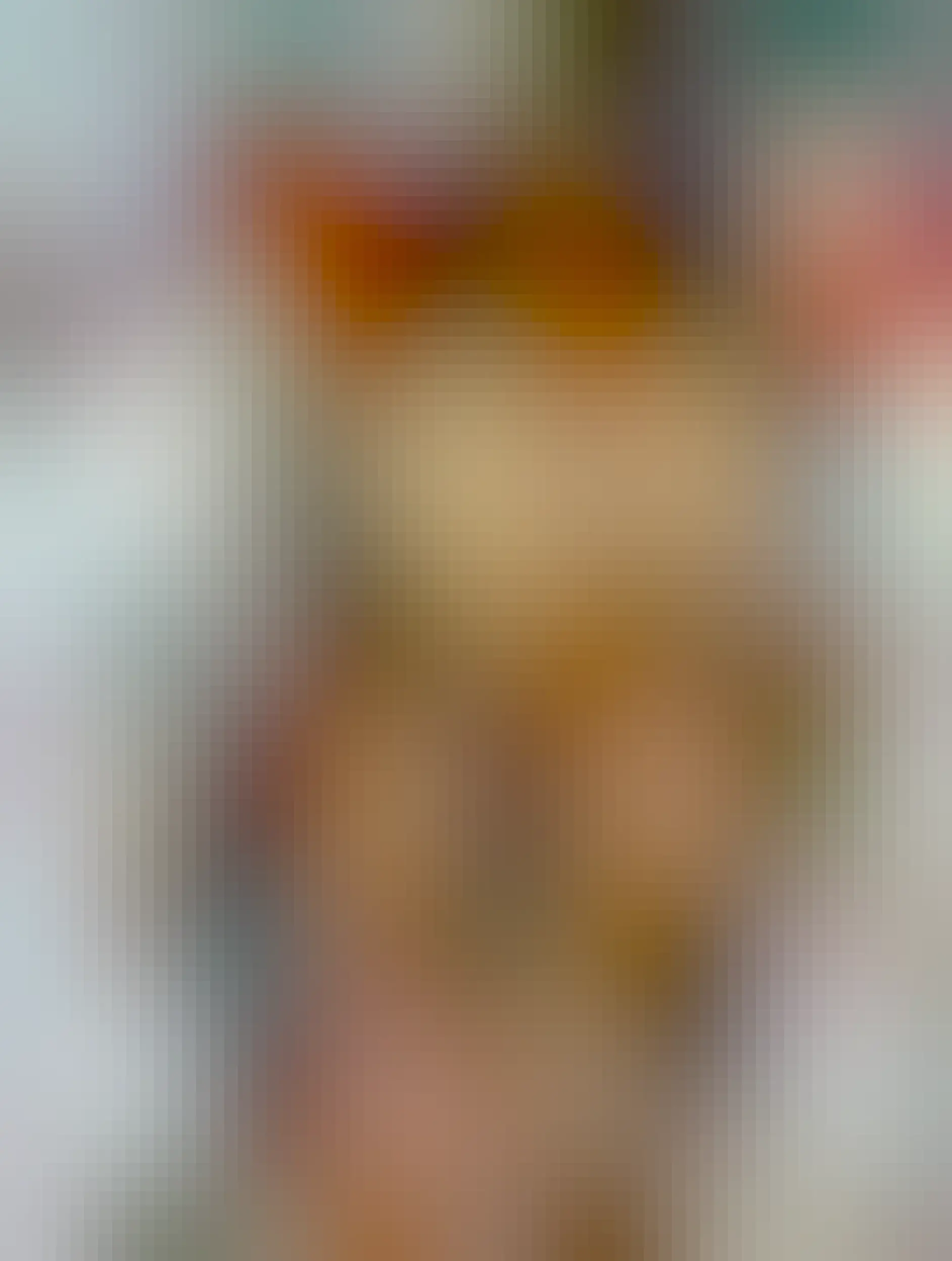 Two orange cats snuggling on a bed.