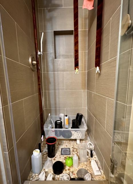 A photo of a bathroom filled with film development equipment, and 3 film strips hanging from above