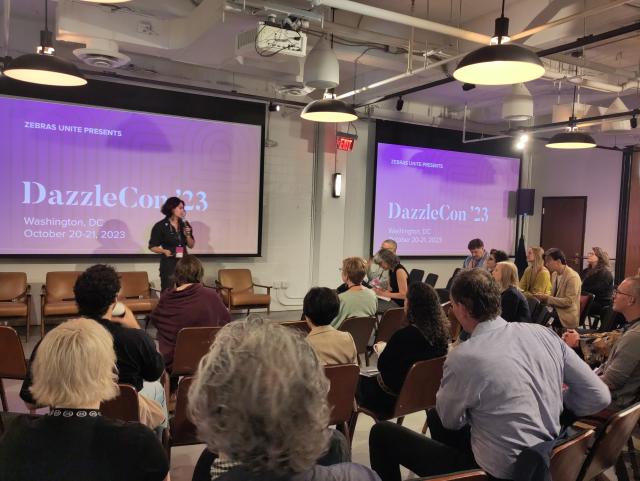 Conference session in front of a screen that says "DazzleCon '23"