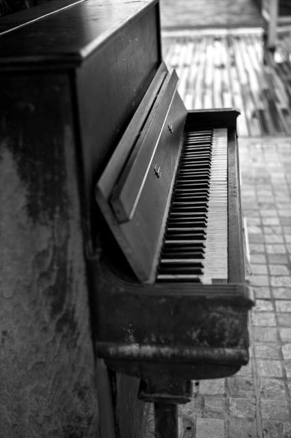 Black and white film photo of the keys of an upright piano