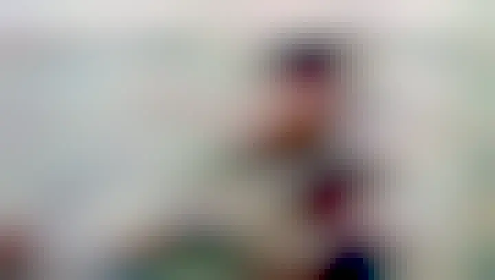 A still clip from the music video shared, of singer, Genevieve, singing into her own mic with a bunch of news mics in front of her.