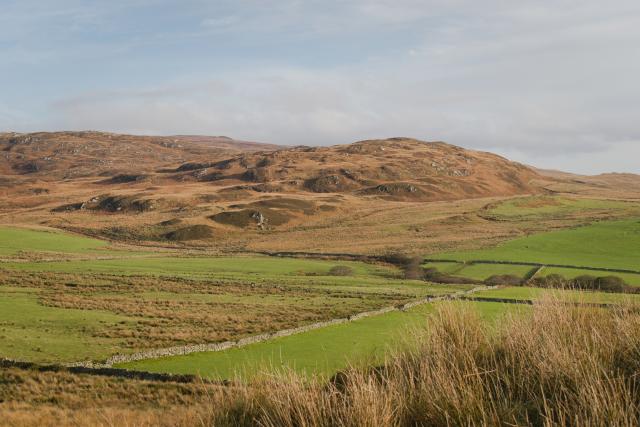 low brown hills and green fields