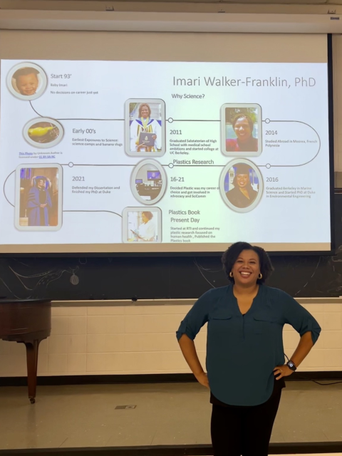 Imari smiling in front of her presentation on screen 