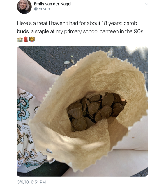 March 9, 2018 tweet by Emily van der Nagel @emvdn "Here's a treat I haven't had for about 18 years: carob buds, a staple at my primary school canteen in the 90s"  with 3 emojis I can't make out.

Photo shows view from above of a paper bag of carob "chocolate" candies held in the hand of a pale person.