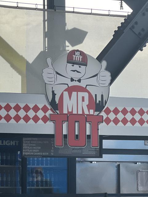 an oddly despondent looking mascot for a stadium food stand 