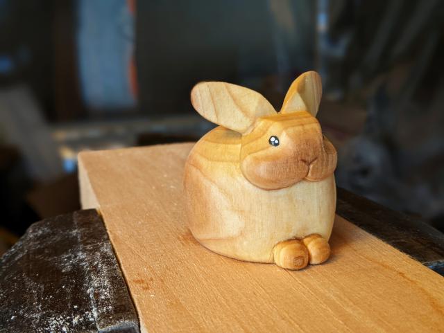 Petit lapin dodu en bois sur un planche prise dans un étau