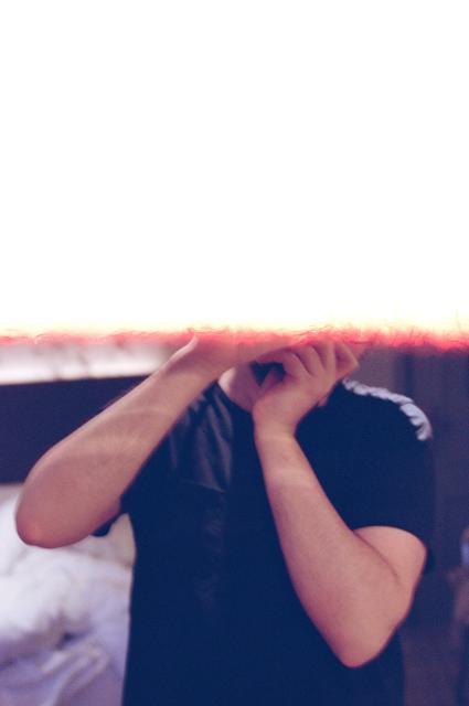 A self-portrait through a mirror, but the top half of the picture has been exposed to light and is completely blank.