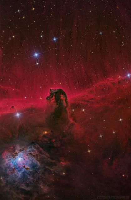 A dark nebula resembling the head of a horse is imaged before a red-glowing background. Stars appear throughout the image.