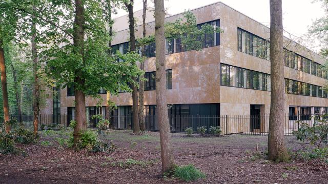 Photograph of the outside of the Max Planck Institute in Nijmegen, surrounded by trees.