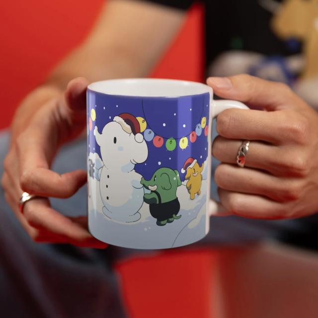 The Mastodon winter mug. On it, you can see little colorful elephants build an elephant-shaped snowman, with snow and fairy lights in the background.