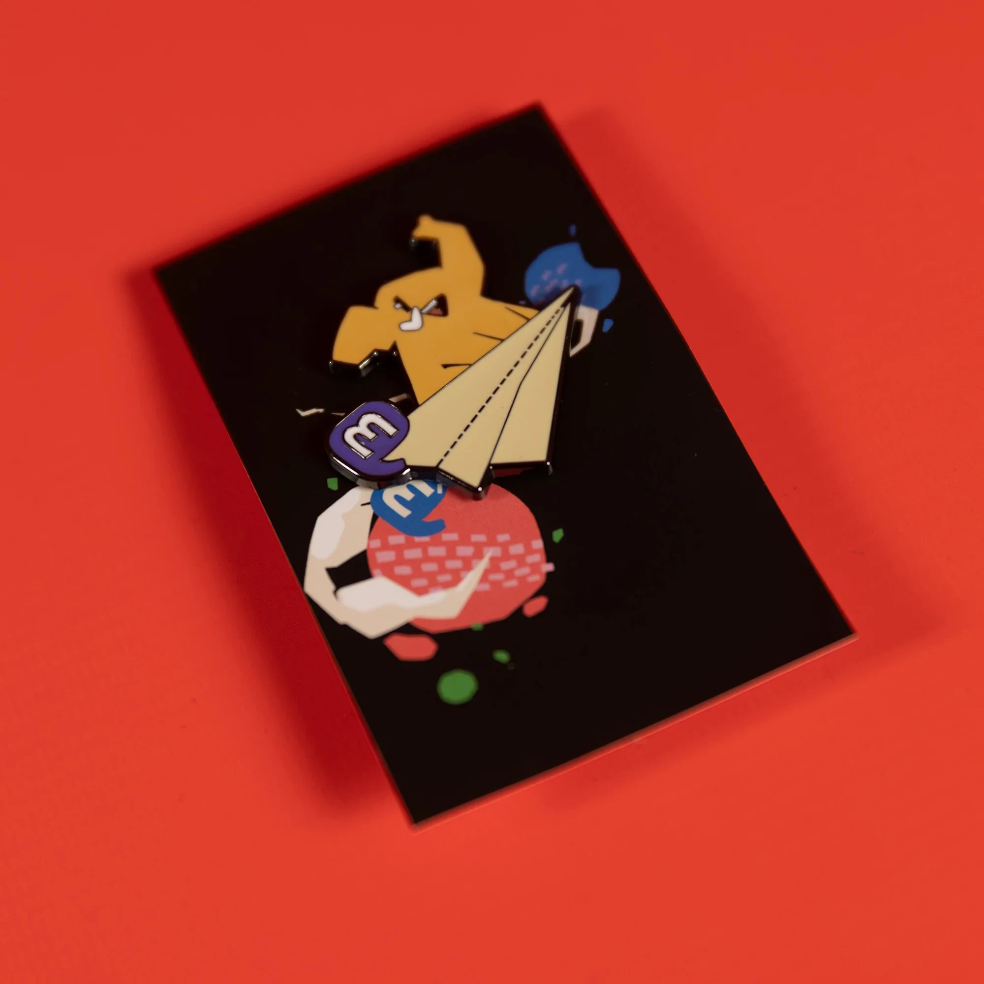 The Mastodon enamel pin, featuring a happy elephant fly on a paper plane, with the Mastodon logo on the side.