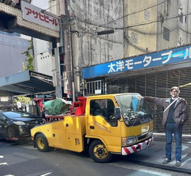 Me standing next to a tow truck that is shorter than me