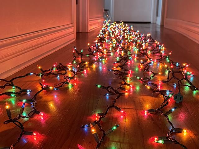 Testing the multi-colored Christmas lights by running them down the hall before putting them on the tree.
