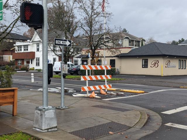 Photo I took of the High Street bikeway at the intersection of High Street and 13th Avenue in Eugene, Oregon. The bike lane is currently closed off with an orange and white barrier.