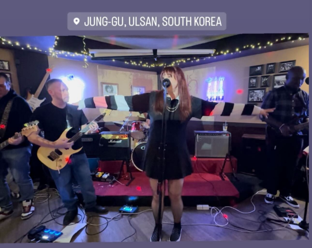 A photo from my band’s gig last night of my singing with my arms stretched out to either side (idk, I was pretending to fly or something haha) 