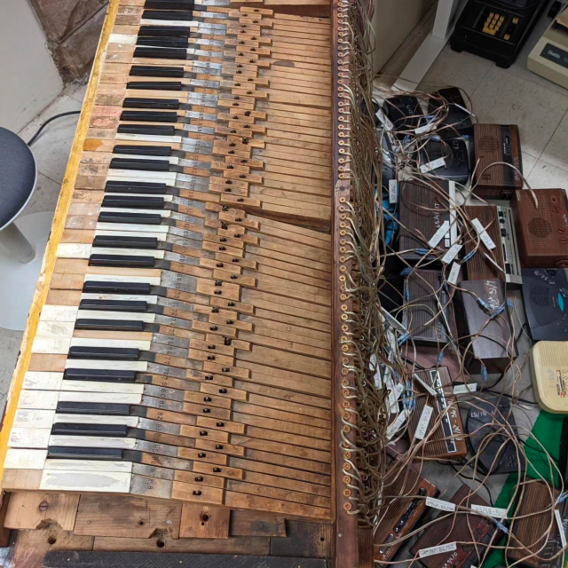 another view of Emily Francisco's Trans-Harmonium - a skeleton of a piano with each key wired to a different clock radio