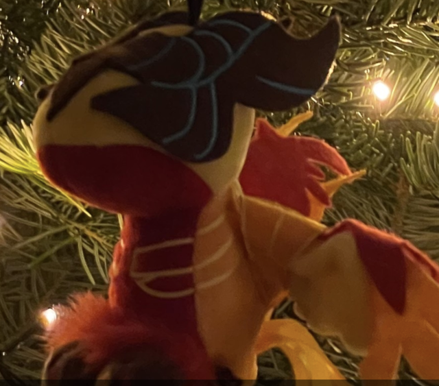 An orange-yellow-red dragon plushie on the christmas tree, I think?