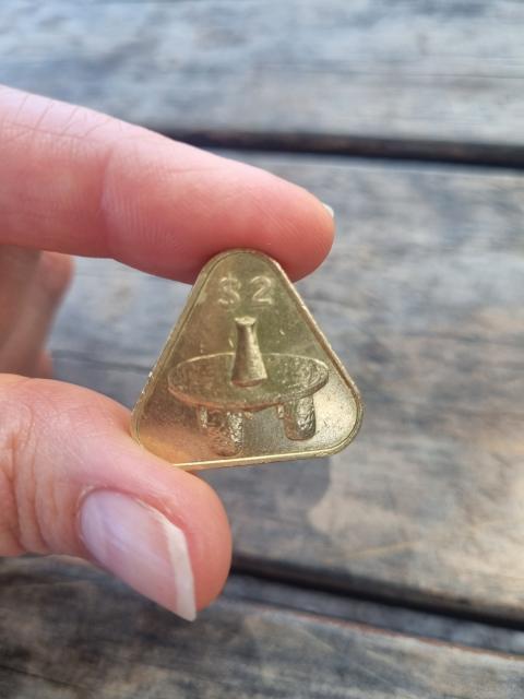 Little triangle coin with a table and vase on it