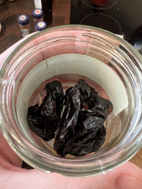 Small glass jar of weird dark shrivelled things in it. Smoked dried habanero.