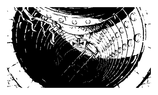 An illustration of a long elevator shaft seen from above drawn in a 1-bit black & white style. The glancing sunlight hits its circular wall segments at an angle, but doesn't reach very far -- from our point of view, the pit might as well be bottomless. Deep down we see glimpses of some bridge-like structures that connect the openings in the wall of the shaft, but that's about it; anything deeper is covered in total darkness. On the surface, directly above the opening hang the remains of a mechanism, covered in creeping vines. It looks like the mechanism is missing some bits that perhaps fell down into the abyss.