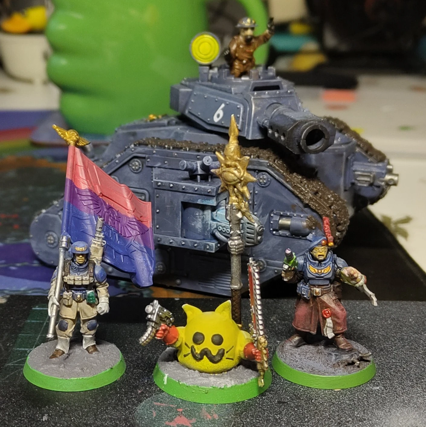 Chaos blobcat mini surrounded by imperial guard: a bisexual standard bearer, officer and a leeman Russ tank