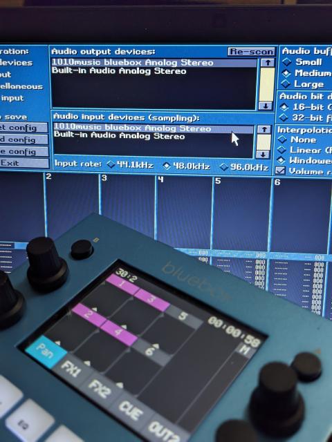 Photograph shows a 1010Music Bluebox mixer in the foreground and a computer monitor in the background.

The computer monitor displays Fasttracker 2 Clone's audio interface settings. The 1010Music Bluebox option is selected for both output and input.