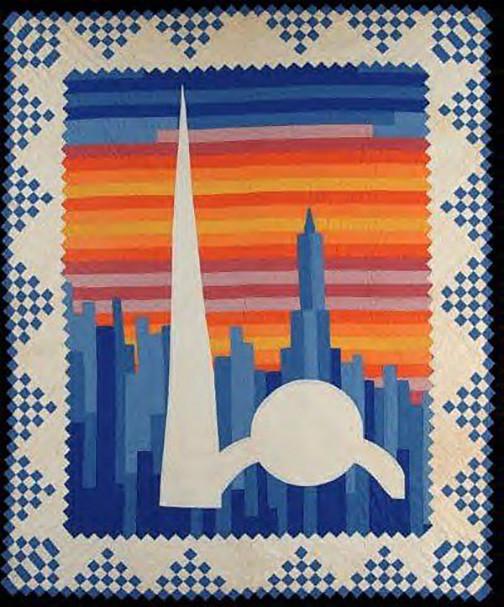 Quilt in full, the center is a vertically strip pieced NY skyline in shades of blue against a horizontally strip pieced sky at sunset. The NY World's Fair logo of a tall triangle and smaller disk is appliquéd over that design. A wide outside border of blue and white checkerboard half-square triangles finishes off the design
