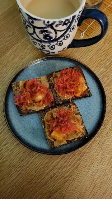 Yummy toast on a blue plate with a bucket of spice tea behind.