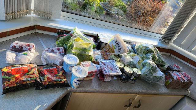 Shopping spread out on a counter. Greens and veg heavy.