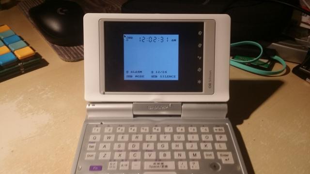 A Zaurus Husky, a small clam-shell mobile computer, with a thumb-typing qwerty keyboard with some Japanese symbols, showing a timer interface on its screen.