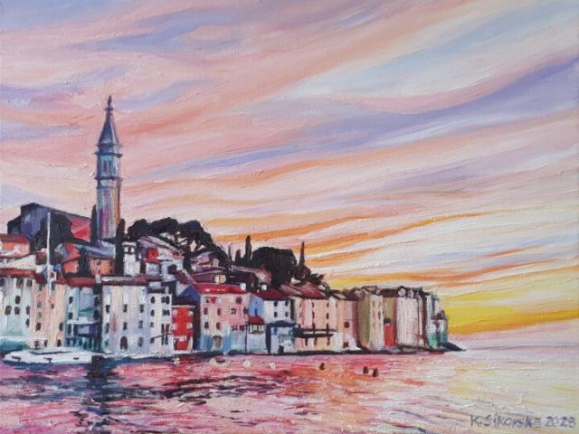 Bit abstract and creative colourful painring of the city of Rovinj with the mainly pink coloured ocean in the foregound and on the right, and the colourful houses and church of Rovinj on the left. The sky is painted in diagonal rather thin brushes of soft shades of yellow, orange, blue, pink and purple. 