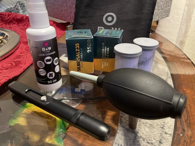 Lens cleaner liquid, brush, air bellows, a bag for them, two rolls of Silbersalz35 250D and two rolls of Kodak Vision 3, one 250D and one 500T. 