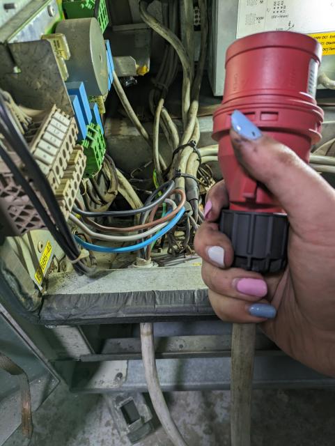 photo of my hand holding a 3 phase powerr cable by the plug. the other end of the cable is connected inside the krc1 enclosure.