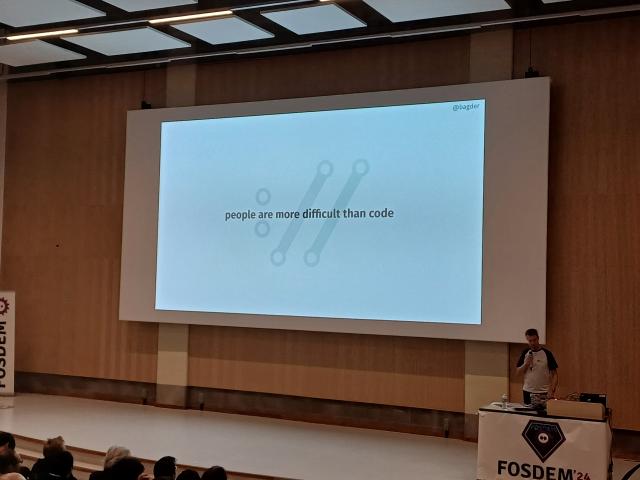 Presentation slide that says "people are more difficult than code"