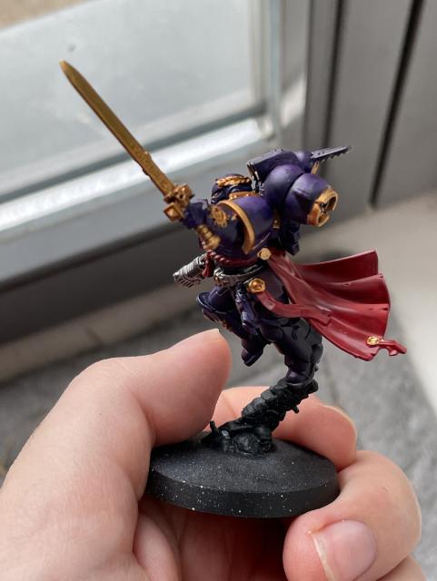 A Space Marine Captain with Jumping Rack painted in purple, red, and gold. Side view.