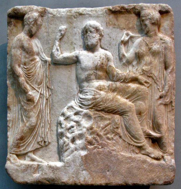 "Asclepios is sitting on an omphalos between his wife Epione and a man clad in himation."

Tilemahos Efthimiadis, CC BY-SA 2.0, via Wikimedia Commons. Color and cropping edits.