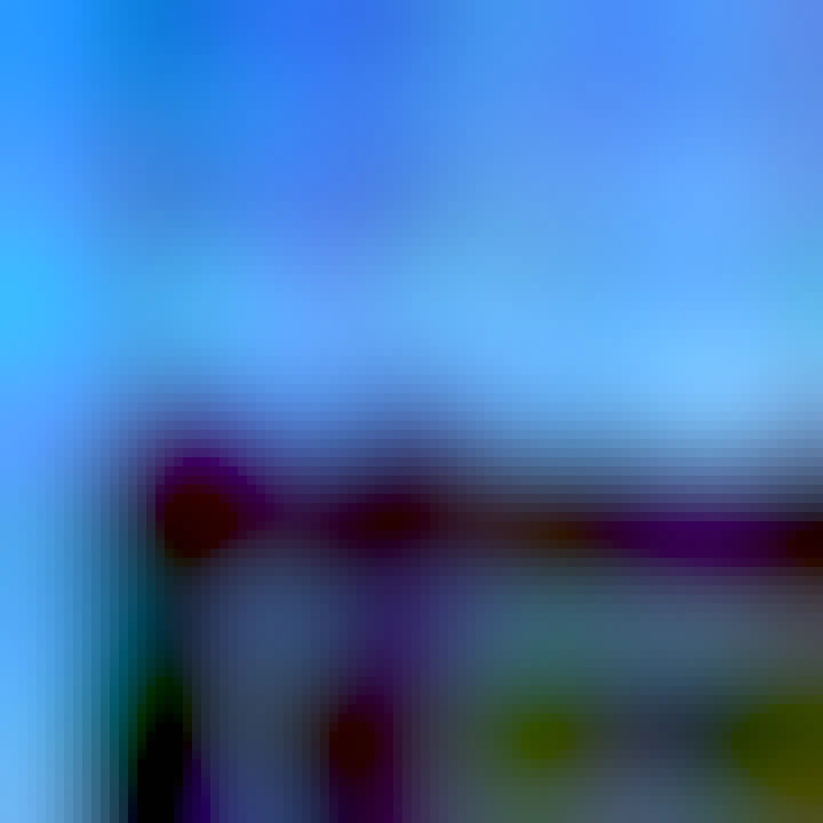 A cat face visible just above a flat roof, looking down towards me. Above a dark grey-blue evening sky. 