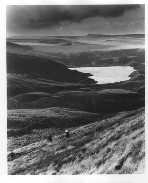 A black and white print of a reservoir in a valley