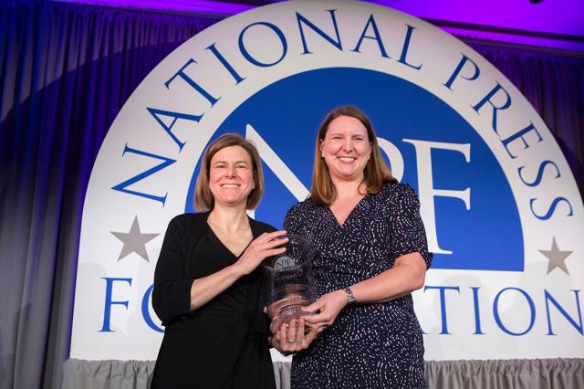 Jen Sorensen receiving Berryman Award vase from National Press Foundation President Anne Godlasky 