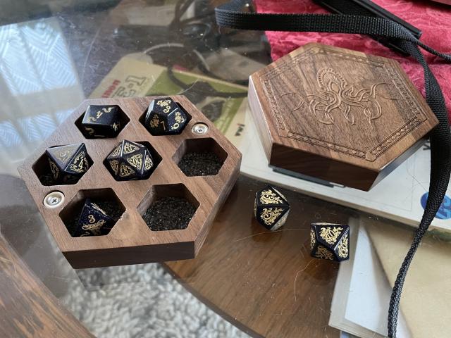 Blue sandstone dice in a wooden container. 