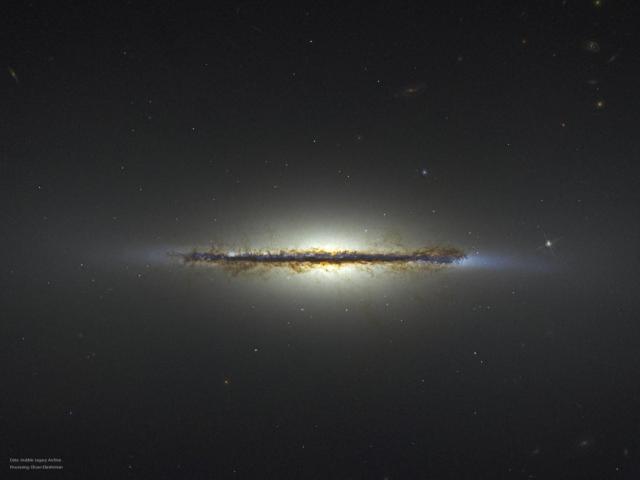 A starfield is shown with an unusual horizontal line segment running throug the middle. The segment is an edge-on galaxy and many brown dust filaments are visible.