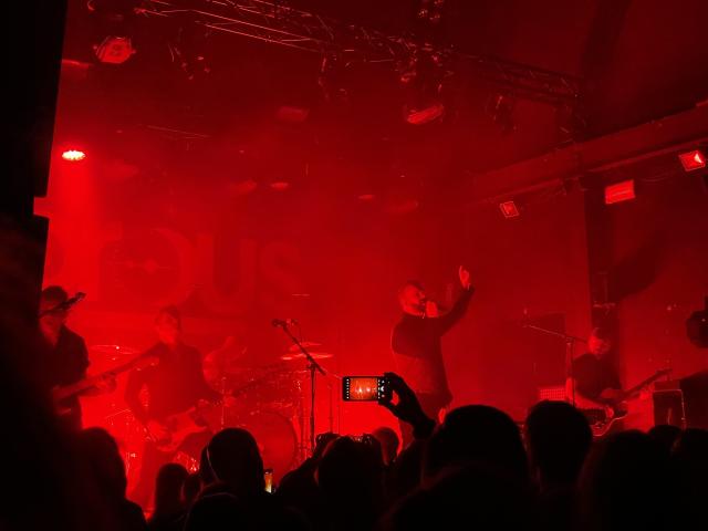 The band on stage illuminated by red light. 