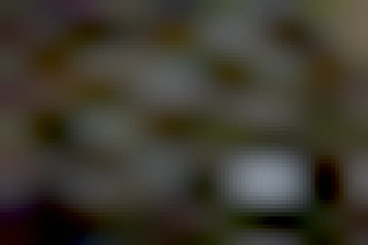 Photograph of an art installation in a room, made up of six near-circular shapes with weaved drawings inside them made from black wire, and lights wired through them. In the background is a library.