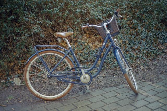 A blue, vintage bike, covered in moisture from the rain.