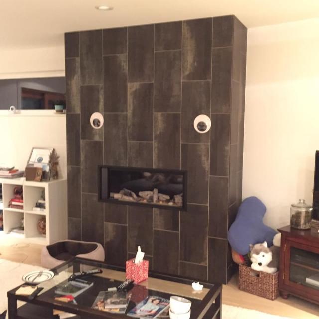 Two giant googly eyes above a rectangular fireplace looking like a shocked face 
