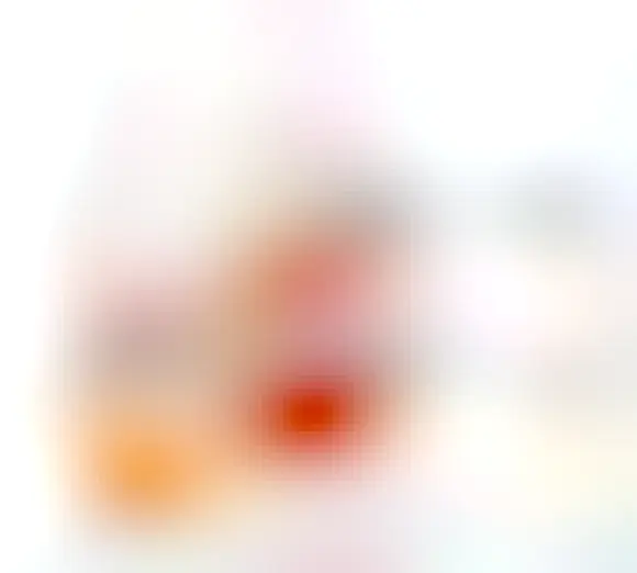 Picture of two jars of honey with spoons in them with curved handles to allow the honey to run back into the jar