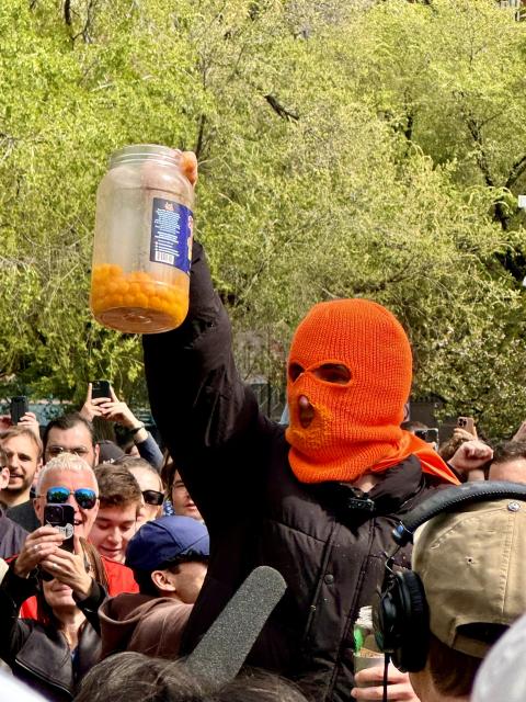 he holds up the jar to the crowd, now a quarter full