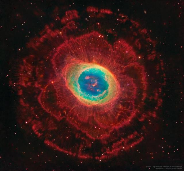 In the center is a colorful nebula, the most usually seen part of the Ring Nebula. Several layers of red-glowing gas with different structures are seen surrounding this center.